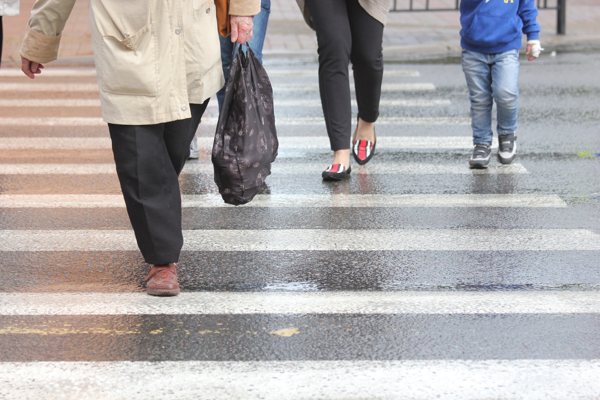 Man on mobile phone cross the road at a pedestrian crossing. Ho