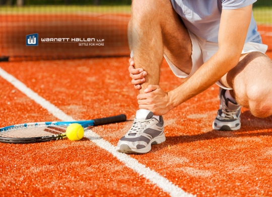 Injured tennis player holding ankle after a sports accident on court — Warnett Hallen LLP sports injury lawyer in British Columbia