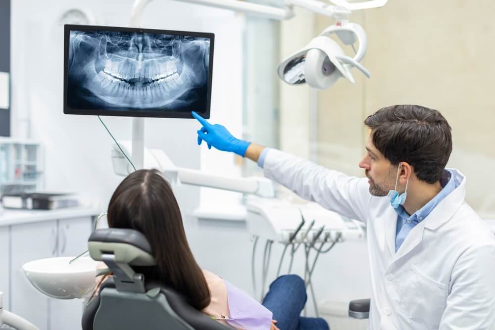 Dentist showing dental X-ray to patient during consultation – Dental malpractice lawyer in Vancouver can help if negligence caused harm.