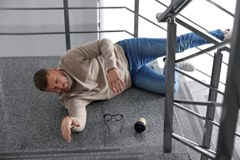 Injured man after a slip and fall on stairs in BC – seeking legal help under the Occupiers Liability Act.
