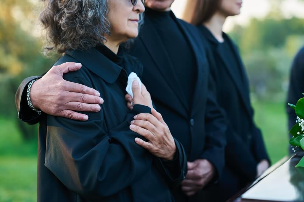 Family mourning at funeral after wrongful death in British Columbia under Family Compensation Act