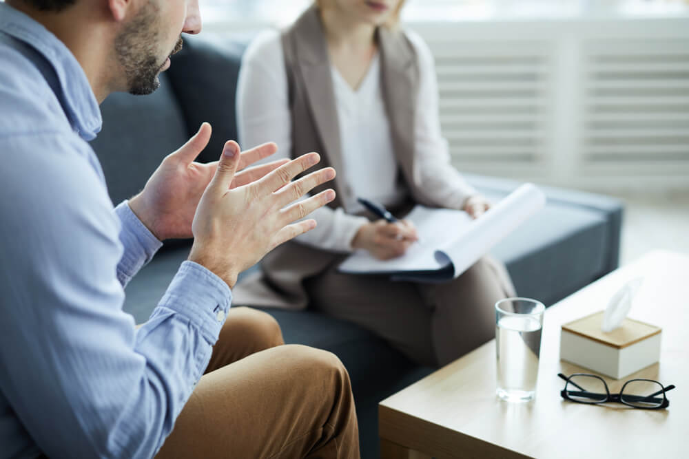 Man discussing alcohol use disorder with a therapist during disability benefits consultation in British Columbia