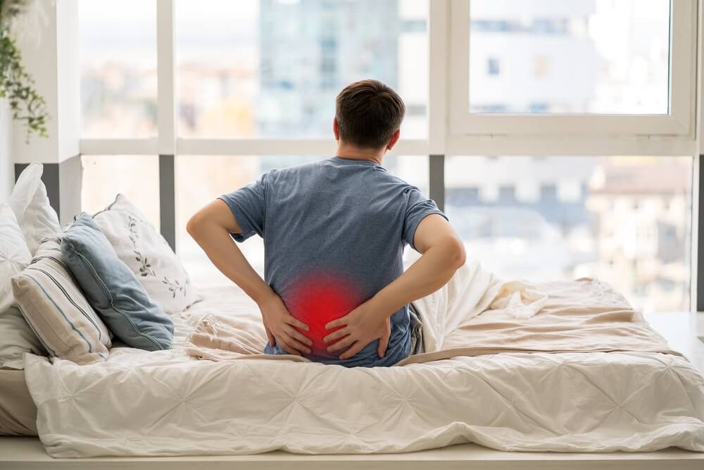 Man holding his lower back after delayed pain from a stadium fall in BC